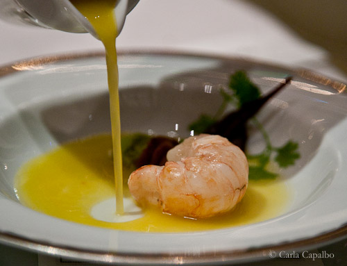 The tucupi being poured onto the langoustine